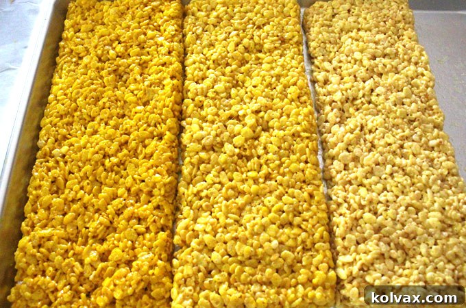 Rows of yellow ombre Rice Krispie Treat mixture cooling on a cookie sheet