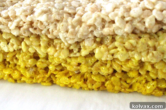 Stacking layers of yellow ombre Rice Krispie Treats