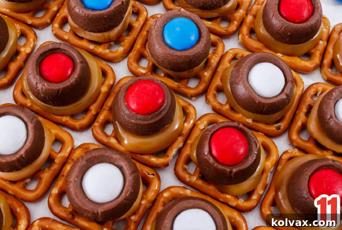 A close-up shot of a dozen finished Patriotic Caramel Pretzel Bites, artfully arranged in neat diagonal rows on a clean white table, showcasing their uniform appearance and festive colors.
