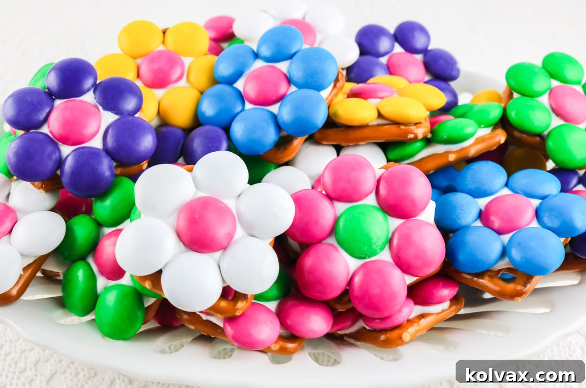 Pretzel Blossom Bites 2 Closeup on a white candy dish filled with a batch of colorful Flower Pretzel Bites.