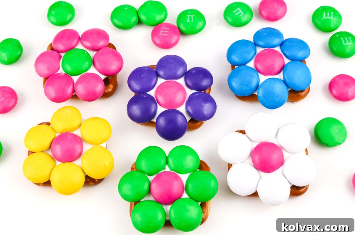 Pretzel Blossom Bites 6 Six flower pretzel bites in different color combinations laying on a white surface.