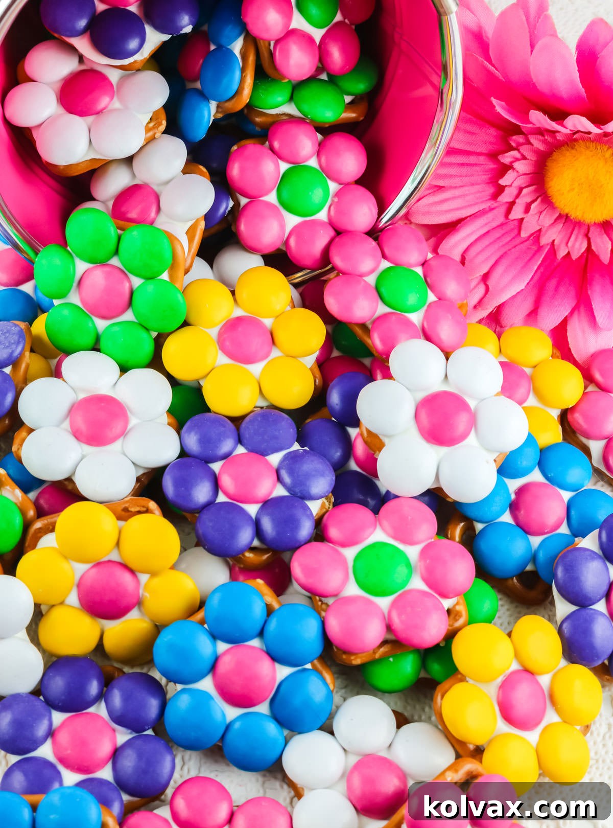 Pretzel Blossom Bites 7 Closeup on a large batch of Flower Pretzel Bites spilling out of a pink pail onto a white tablecloth.