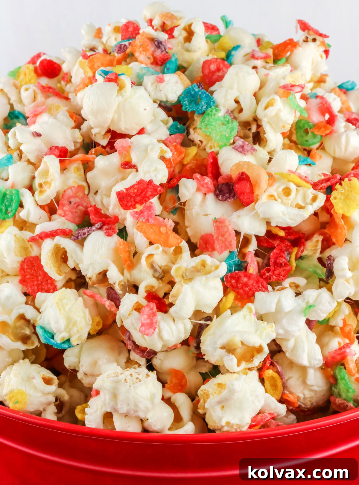 Red serving bowl filled with Fruity Pebbles Popcorn.