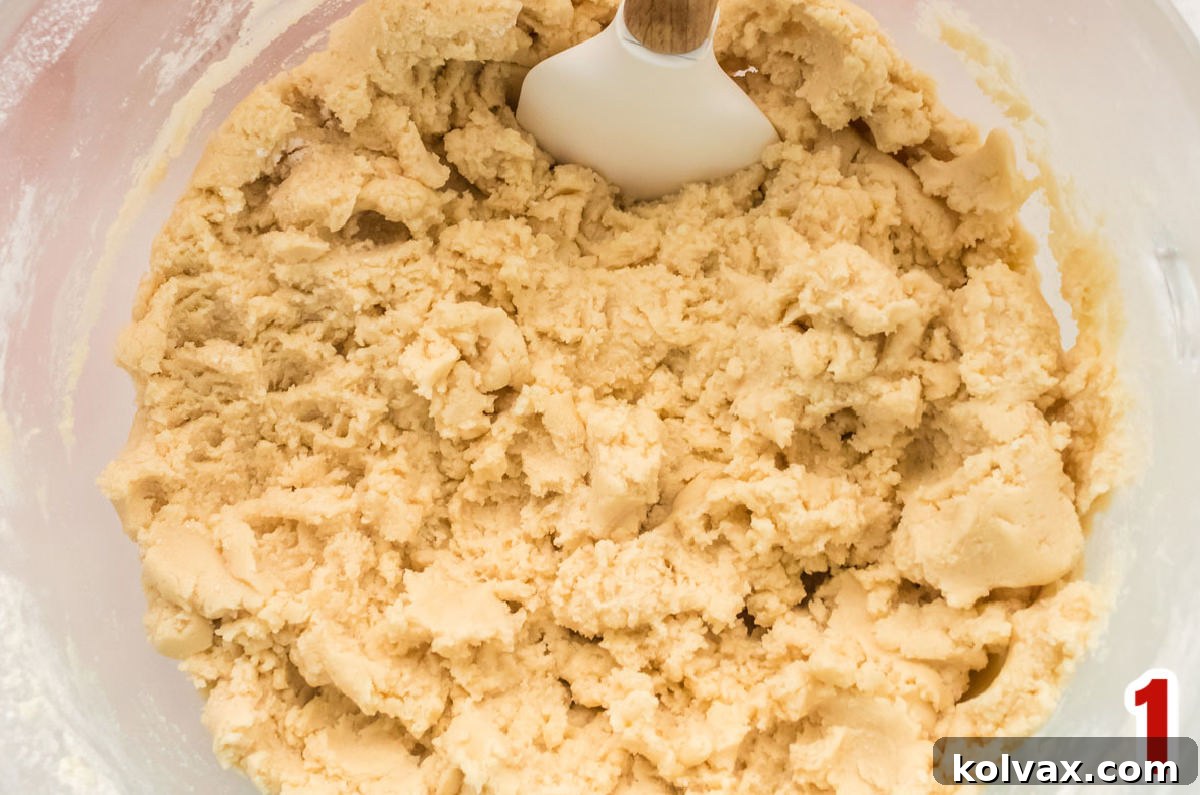 Closeup on a clear mixing bowl filled with smooth, pliable Sugar Cookie dough, ready for rolling.