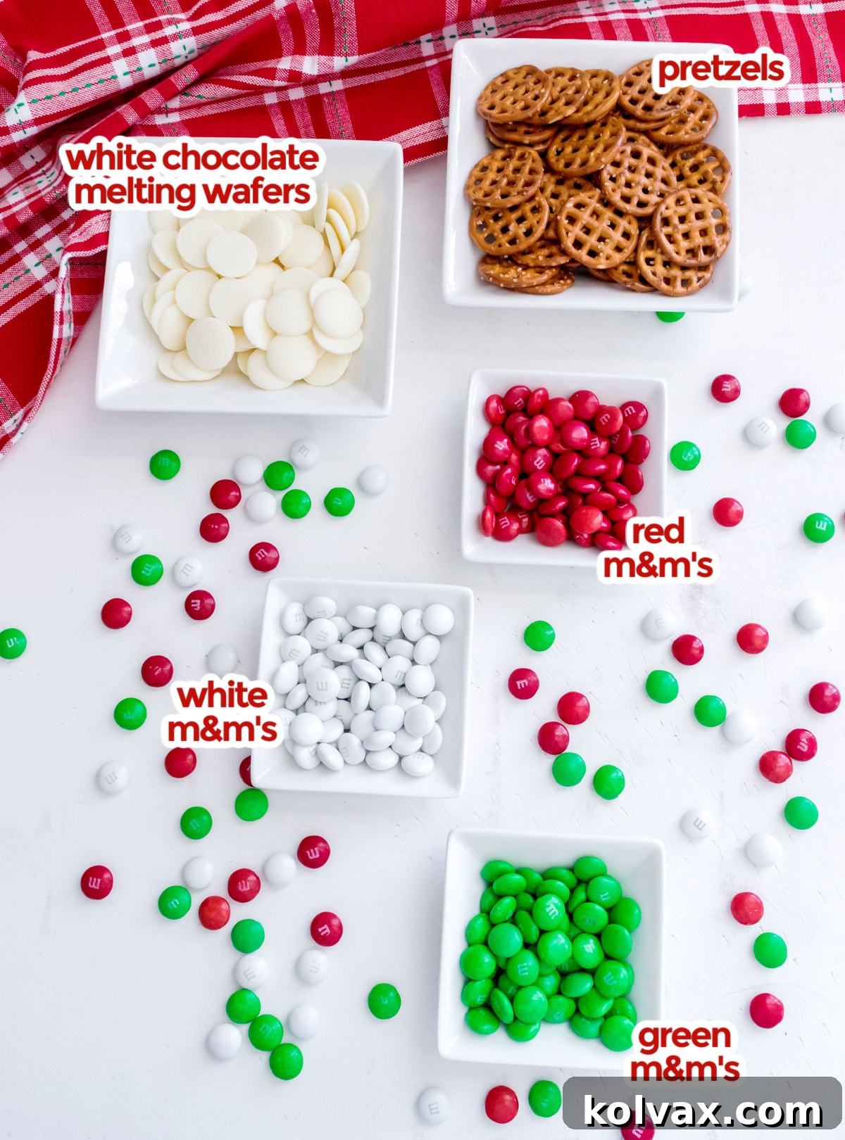 An image showing all the ingredients you will need to make Christmas Flower Pretzel Bites including pretzels, candy melts and Red, White and Green M&M's.