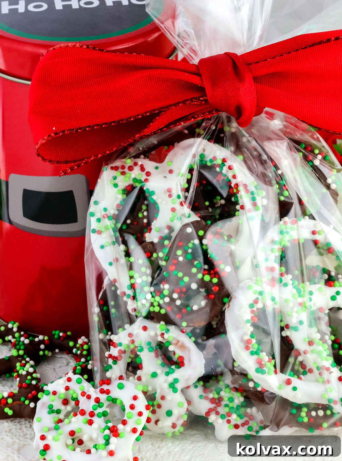 Sweet and Salty Chocolate Pretzel Perfection 5 Homemade Chocolate Covered Pretzels in a clear plastic bag, tied with a red bow sitting on a white table, ready for gifting.