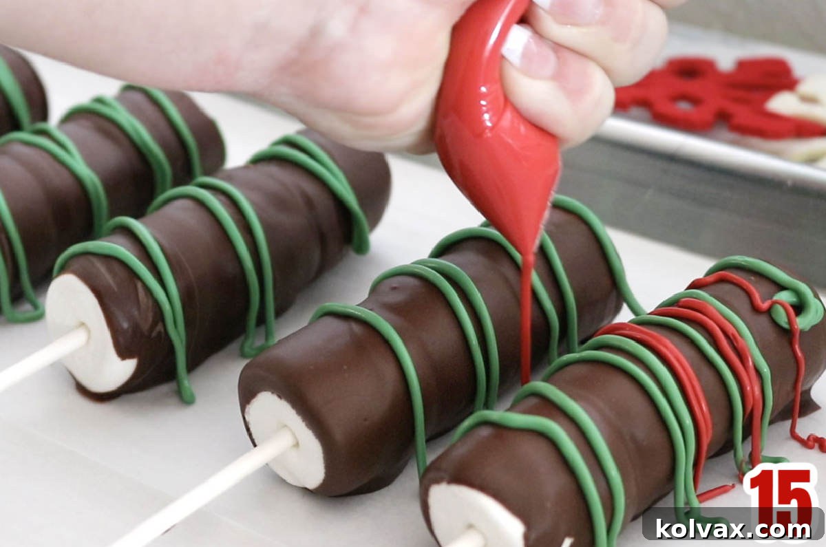 Five undecorated Marshmallow Pops being drizzled with red and green melted Candy Melts, showing the artistic process.