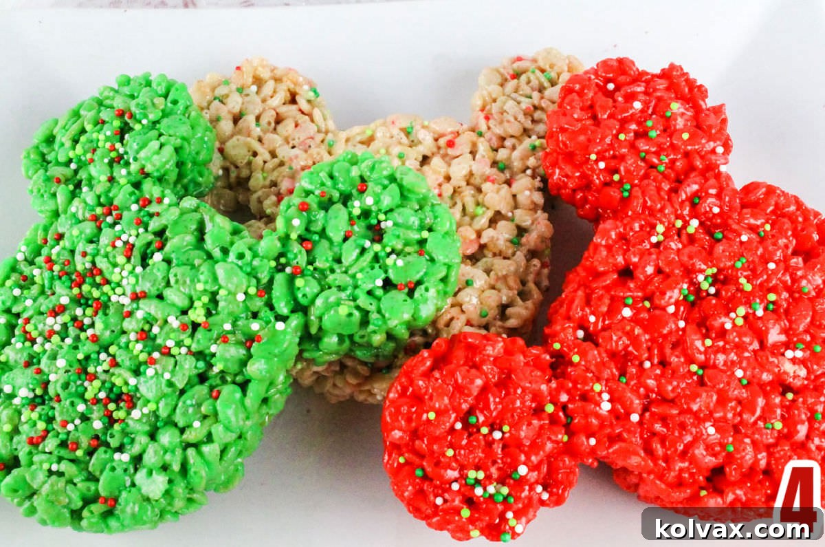 Closeup shot of three finished Christmas Mickey Mouse Rice Krispie Treats, in red, green, and white, elegantly displayed on a white serving platter.