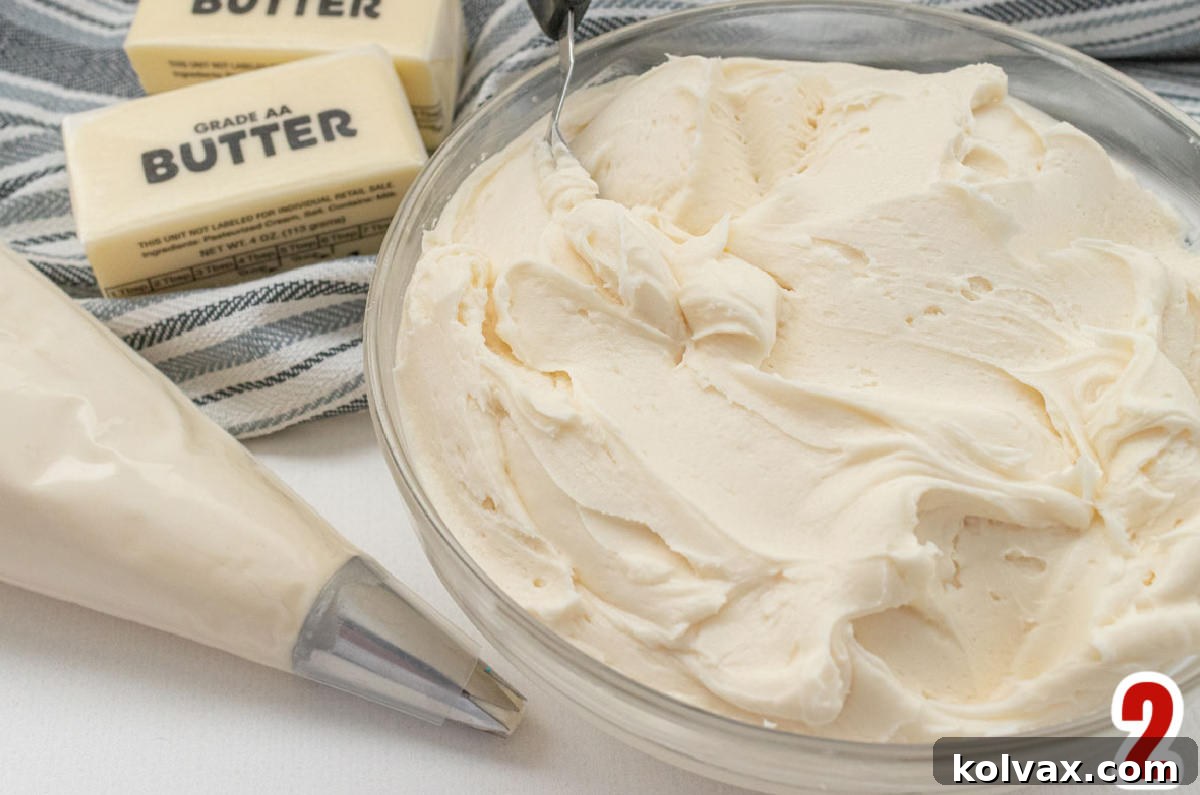 Mickey's Jolly Santa Hat Cupcakes 4 Closeup on a glass bowl filled with homemade buttercream frosting sitting next to a decorating bag filled with frosting, ready for piping.