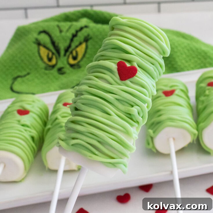 Grinch Marshmallow Pops displayed on a festive platter.