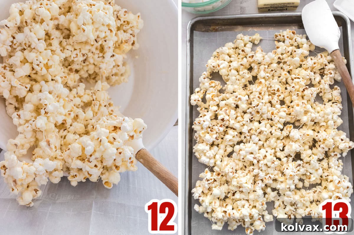 Popcorn coated in marshmallow mixture being spread out onto a parchment-lined cookie sheet to cool.