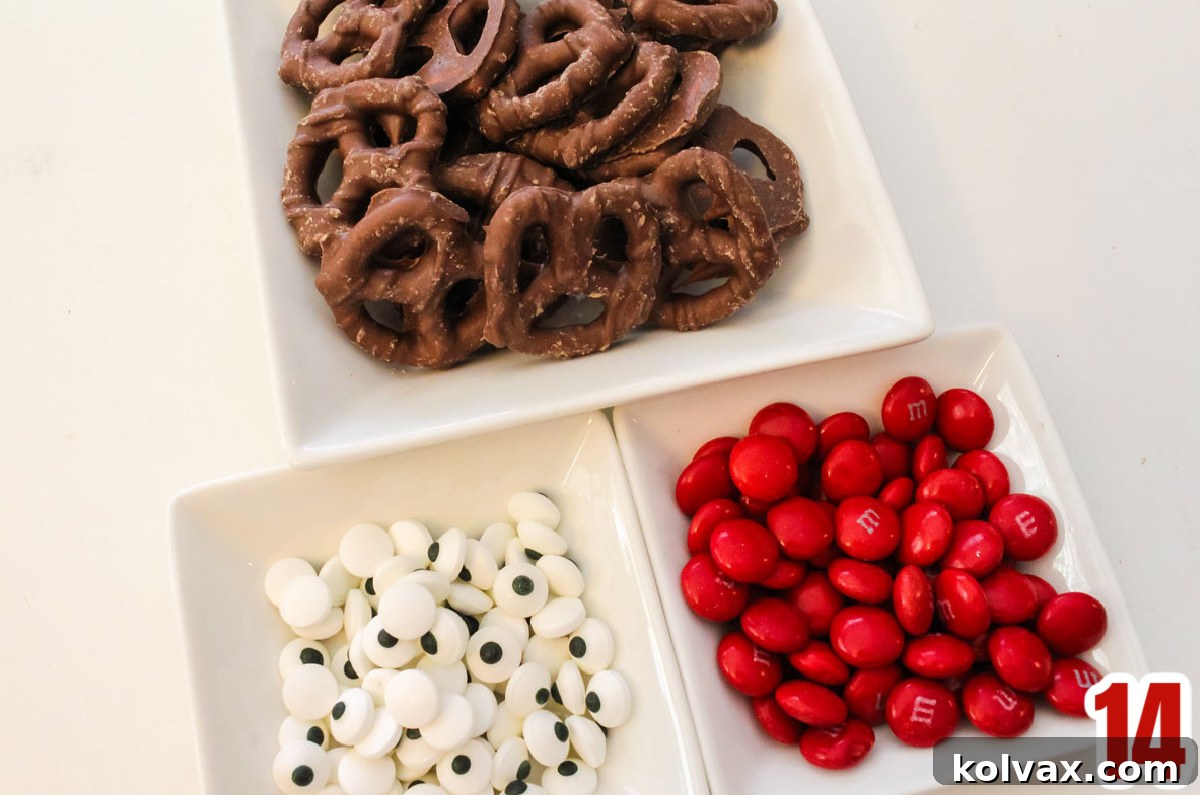 An arrangement of candy mix-ins including Red M&M's, Wilton Candy Eyeballs, and chocolate-covered pretzels, ready for decorating.