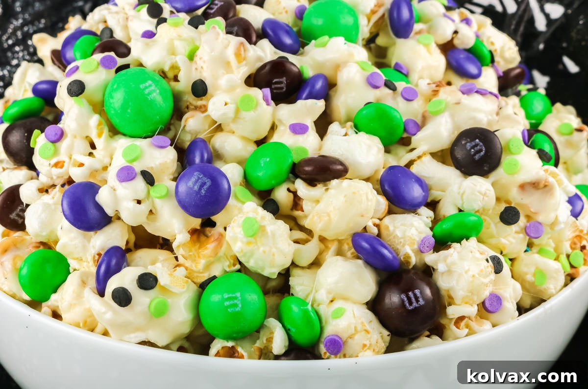 Closeup on a white serving bowl filled with Bewitched Halloween Popcorn, a delightful Halloween dessert.