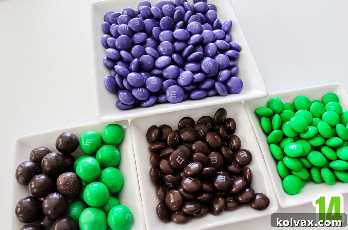 Four white ramekins filled with green, brown, and purple M&M's, ready for mix-ins.