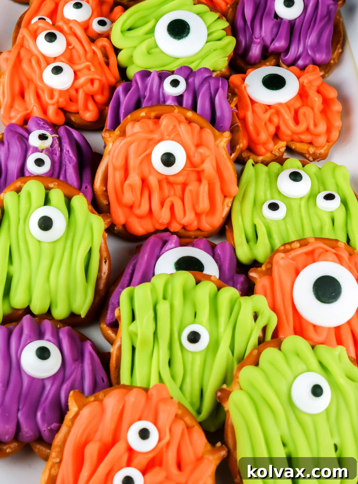A festive white serving platter artfully arranged with a colorful assortment of finished Monster Pretzel Bites, ready for a Halloween party or gathering.