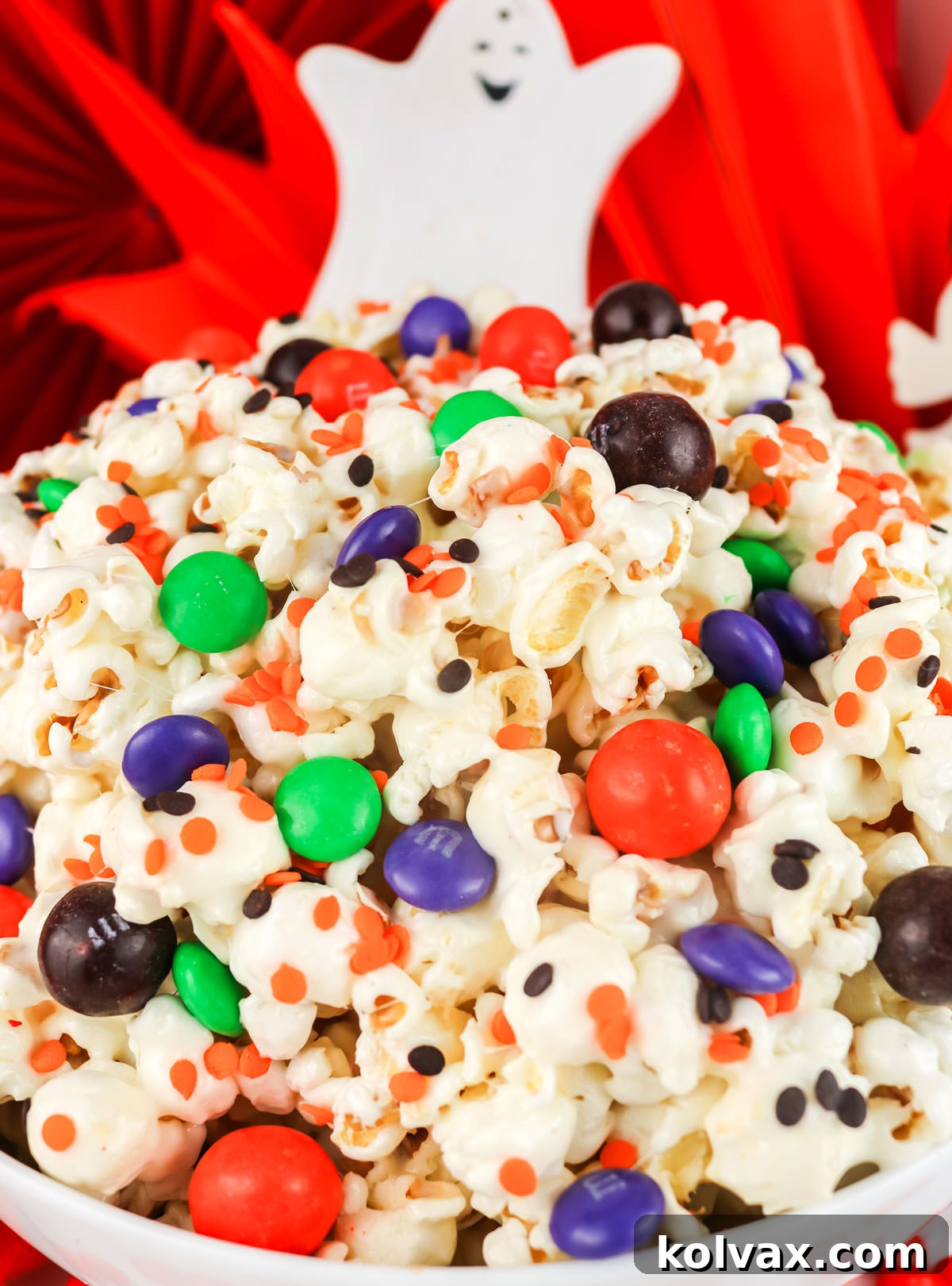 Closeup on a white serving bowl filled with Trick or Treat Halloween Popcorn.