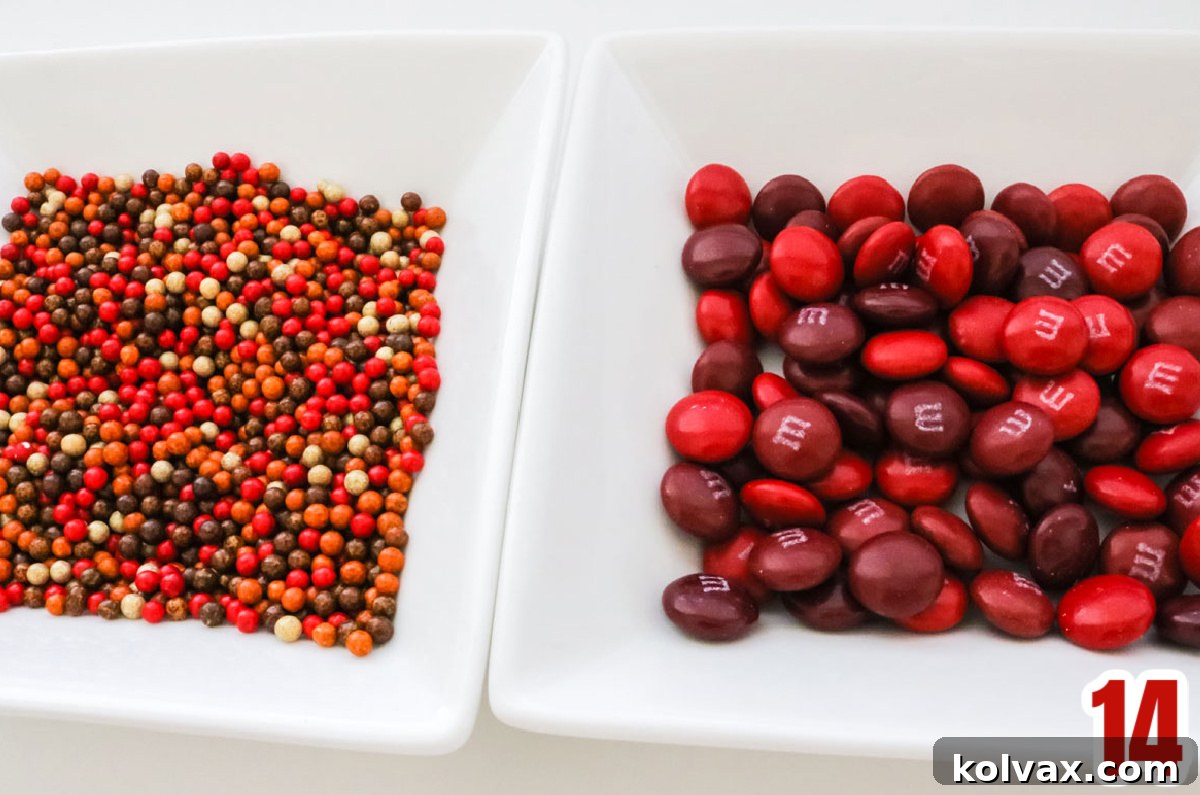Closeup on two white ramekins, one filled with Fall colored sprinkles the other filled with Red M&M's, ready to be added to popcorn.