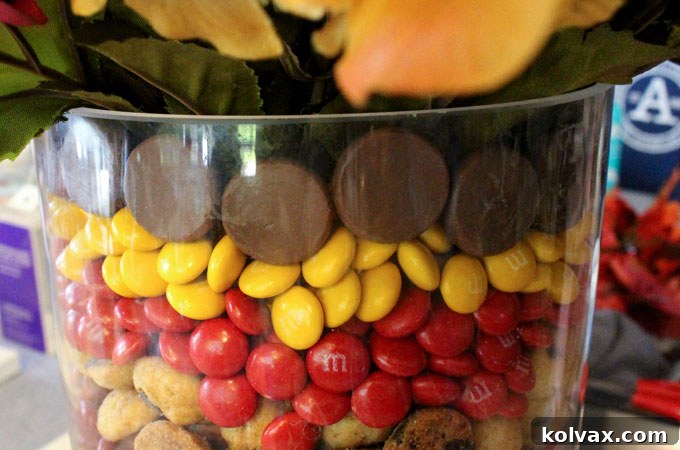 Continuing to fill the Thanksgiving Candy Centerpiece with M&M's after adding a cookie layer