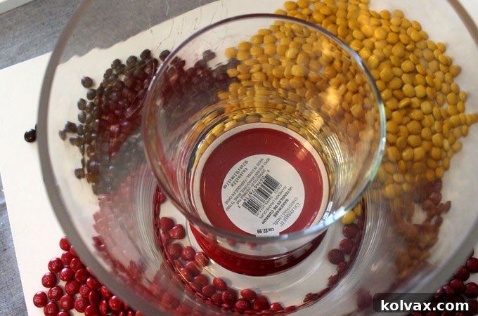 Inserting a smaller vase on top of a ramekin inside the larger hurricane vase for flowers