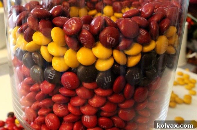 Filling the Thanksgiving Candy Centerpiece vase with the first layer of Harvest M&M's
