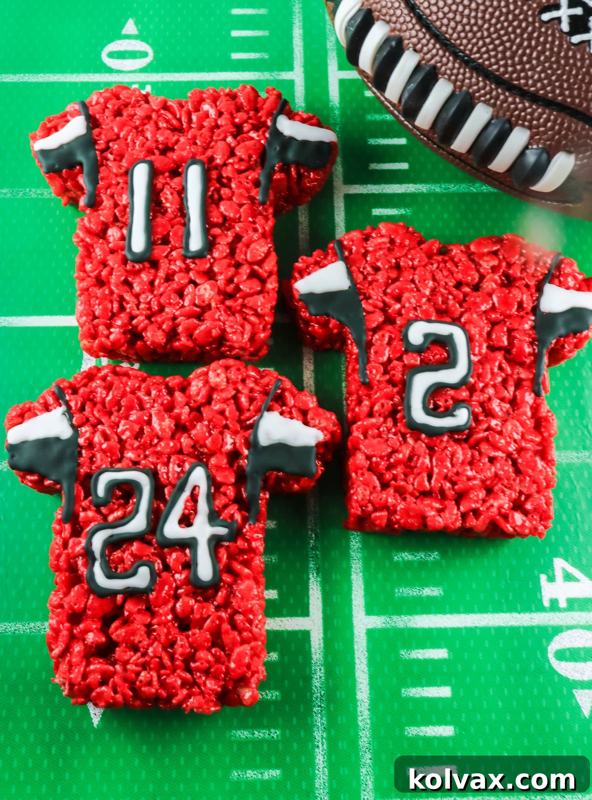 Close-up of three Atlanta Falcons Rice Krispie Treat Team Jerseys displayed on a football field themed tablecloth, ready for game day.