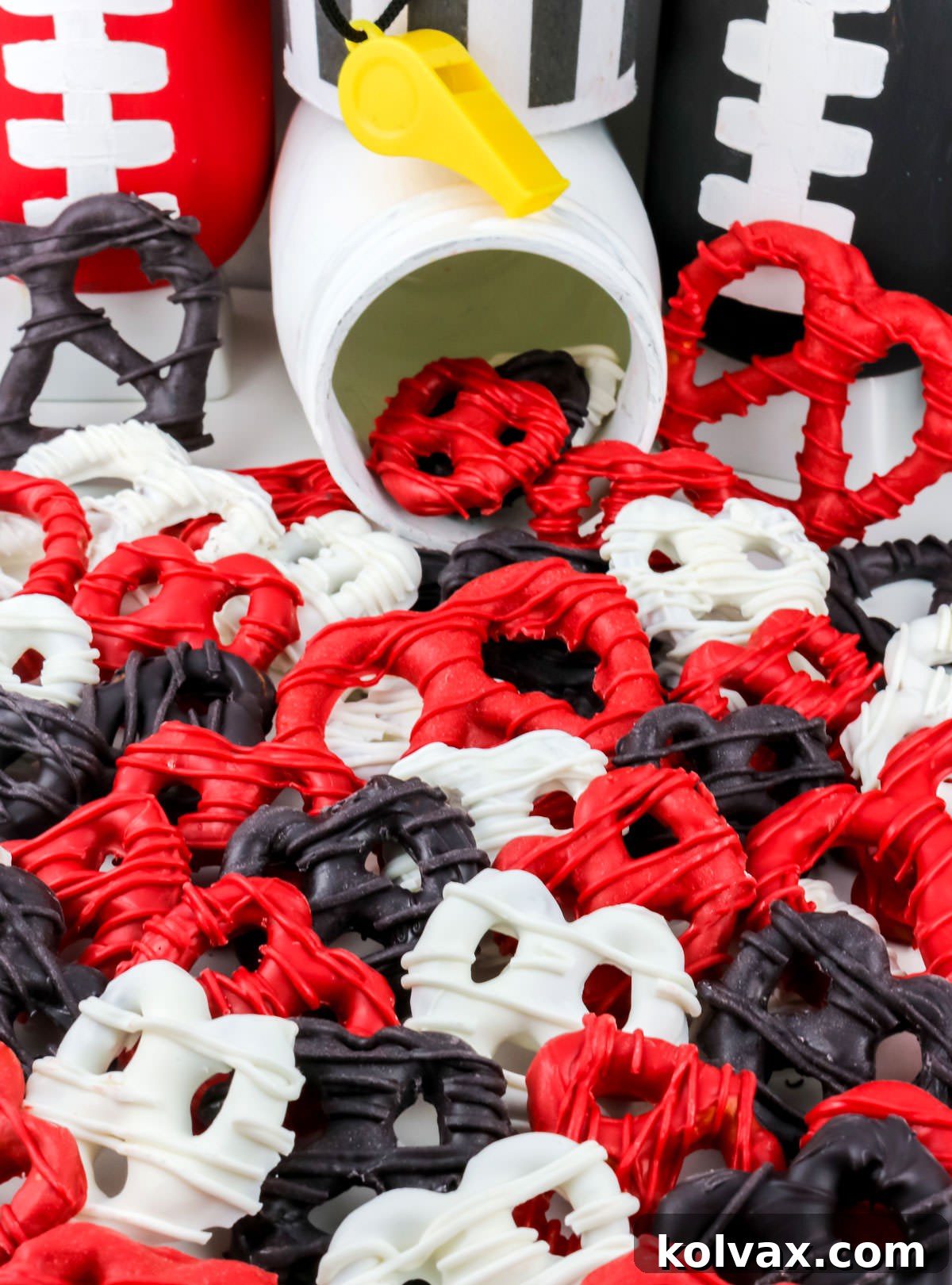 A tempting scattering of Atlanta Falcons Pretzels, elegantly covered in white chocolate and decorated with team colors, on a clean white table.