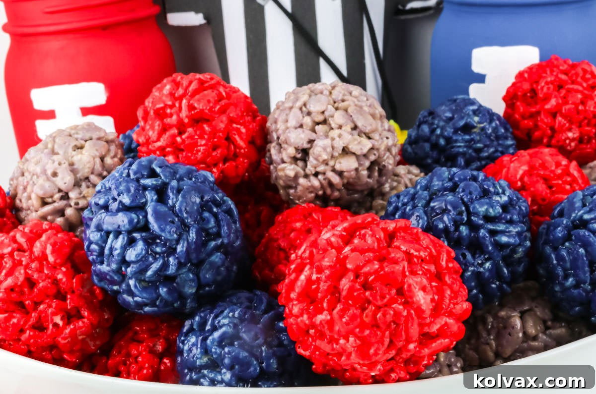 Closeup on a white bowl filled with festive New England Patriots Rice Krispie Treat Bites, artfully arranged amidst football-themed decorations for a perfect game day spread.