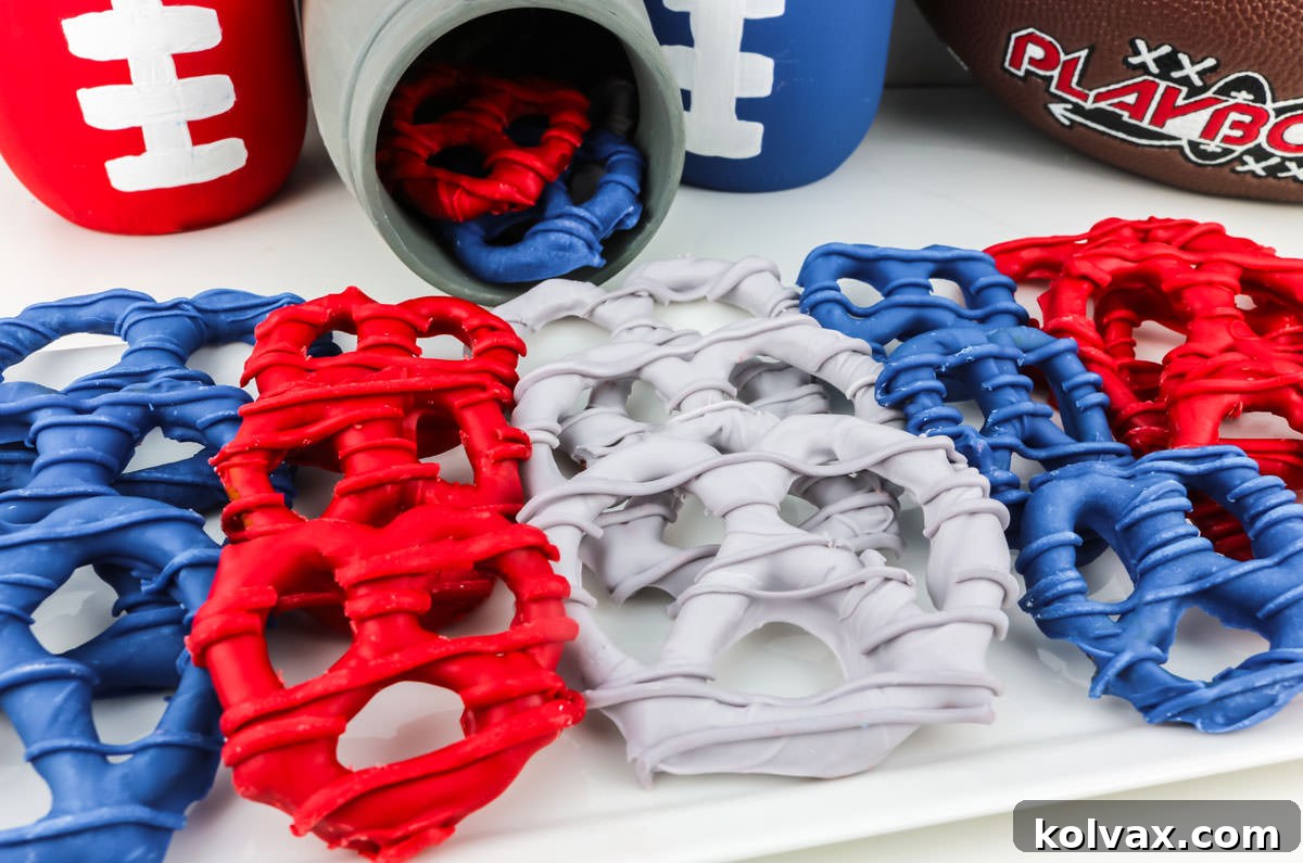 A batch of New England Patriots themed pretzels laying on a white dessert plate, adorned with football decorations.