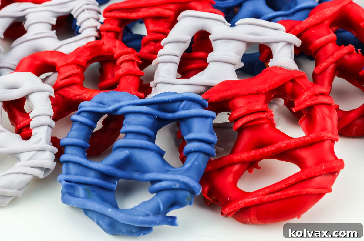 Closeup on a batch of Blue, Red, and Grey New England Patriots Pretzels laying randomly on a white table, showcasing the vivid team colors ready for a game day.