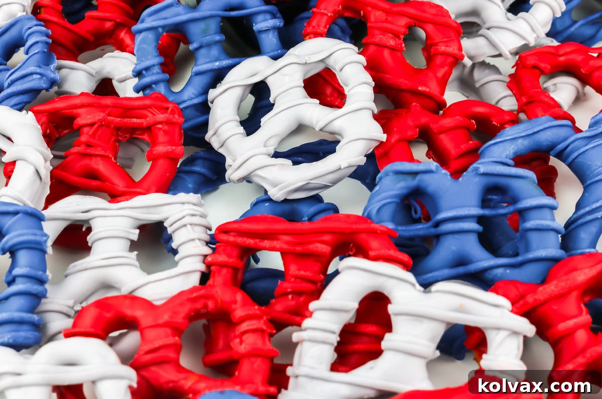 A large batch of New England Patriots themed pretzels laying randomly on a white table, showcasing the finished sweet and salty snacks.