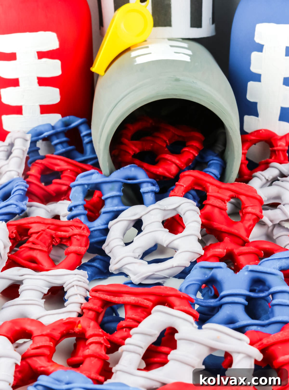 Closeup on a batch of New England Patriots Pretzels tumbling out of a grey football themed Mason Jar, showcasing a creative serving idea.