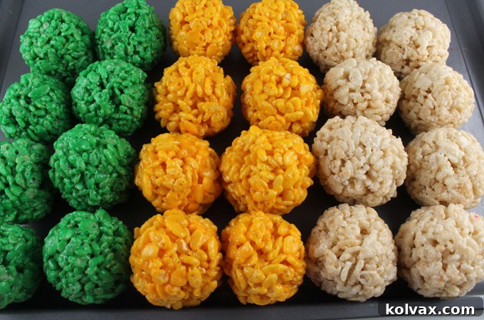 A platter of perfectly formed Green Bay Packers Rice Krispie Bites, showcasing the green, gold, and white colors in a festive arrangement.