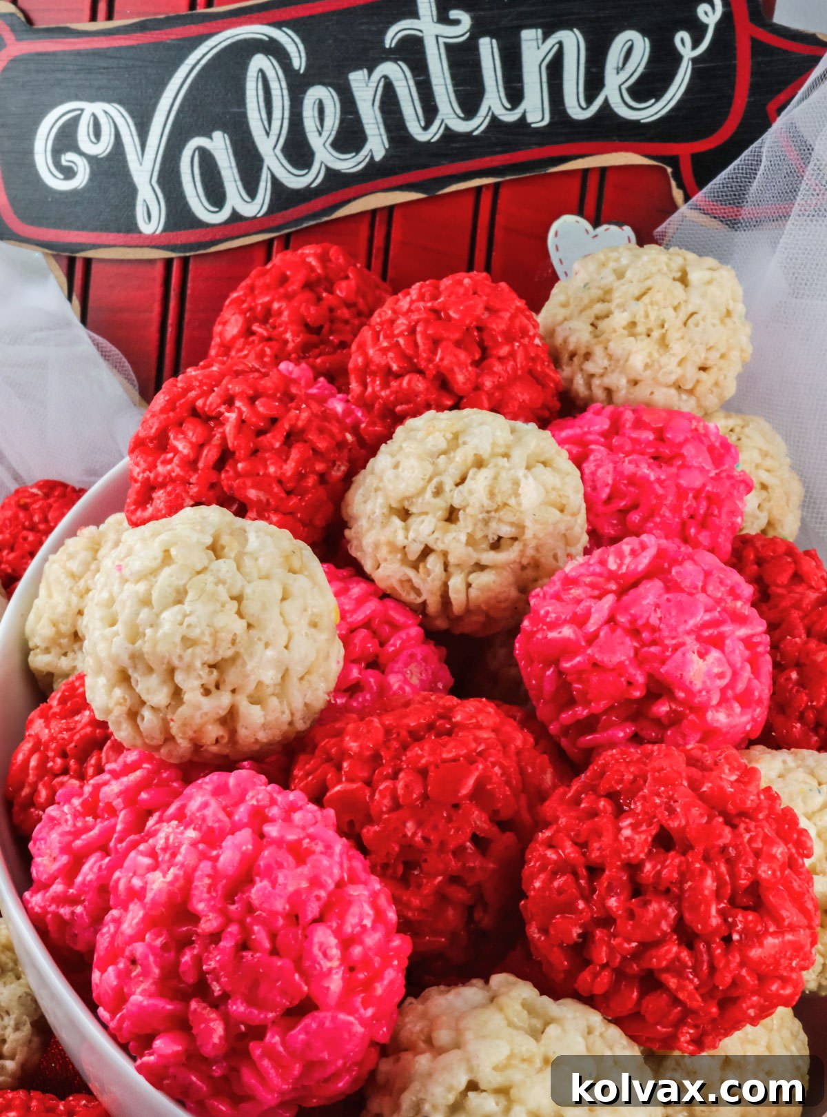 Closeup on a white bowl filled with Red, Pink and White Valentine's Day Rice Krispie Treat Bites.
