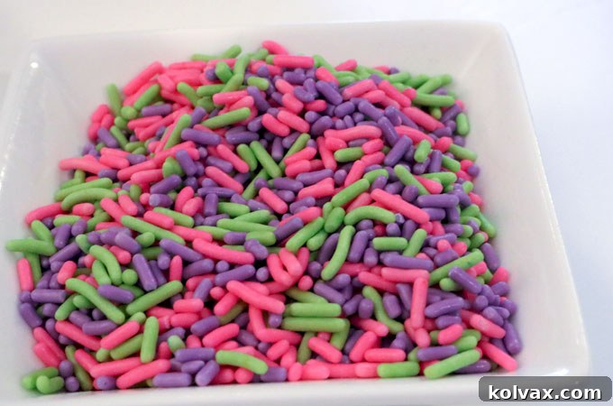 Assorted green, pink, and purple jimmies sprinkles for confetti cake.