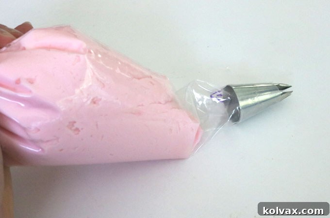 Filling the piping bag with creamy buttercream frosting, leaving room for a secure tie