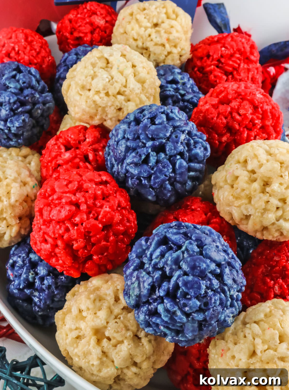 Closeup on a white serving bowl filled with Red White and Blue Rice Krispie Treat Bites for 4th of July.