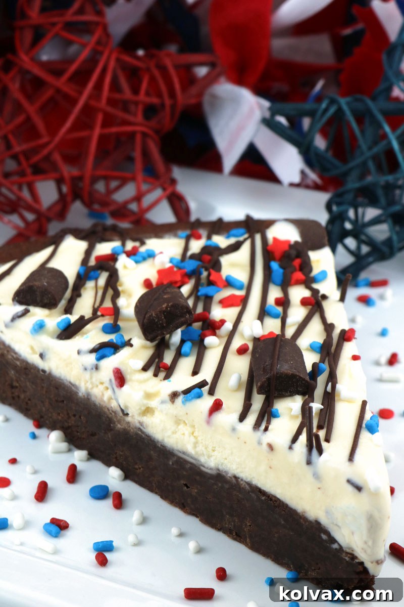 Hand holding a slice of Patriotic Ice Cream Cookie Pizza