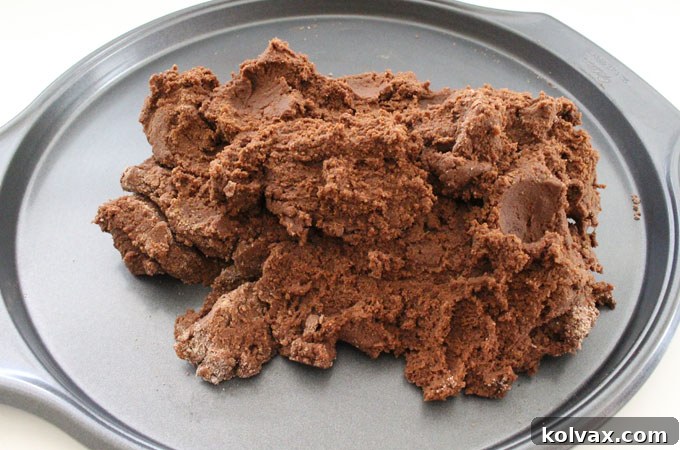 Pouring chocolate cookie dough into a pizza pan