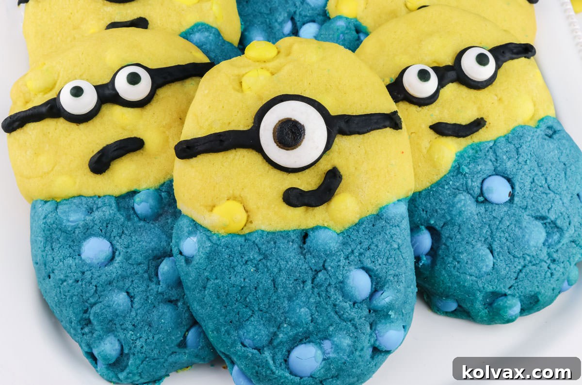 Three Yellow and Blue Minions Cookies sitting on a white serving platter.