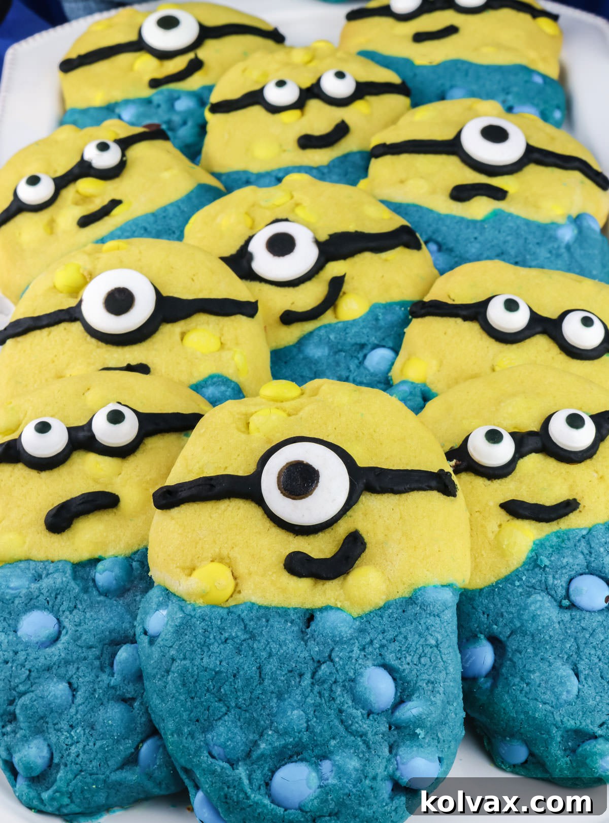 Close up on a white serving plate covered with a dozen yellow and blue Minions Cookies.
