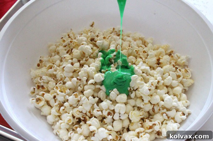 Pouring the mint marshmallow mixture over the salted popcorn.