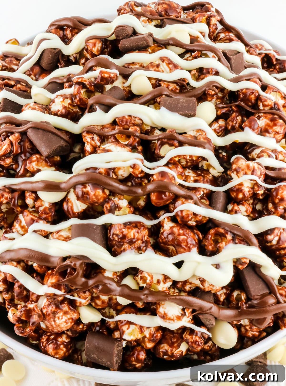 Decadent Pop 8 Closeup on a white serving bowl filled with irresistible Chocolate Popcorn, ready for sharing or enjoying solo.