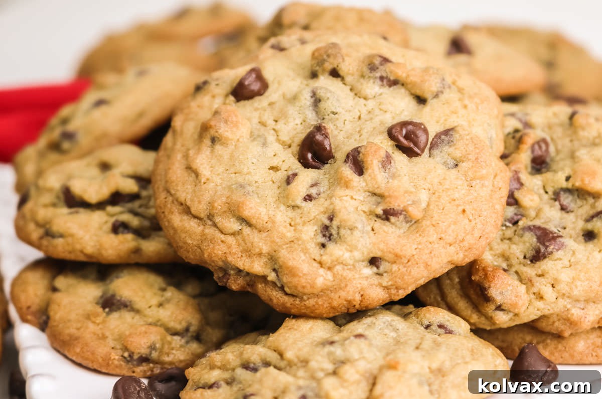 Ultimate Chocolate Chip Cookie Perfection 2 Closeup on a stack of Chocolate Chip Cookies sitting on a white dessert plate, highlighting their golden-brown edges and soft centers.