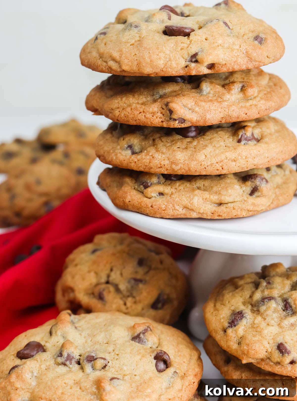 Ultimate Chocolate Chip Cookie Perfection 6 Closeup on a white cake stand covered with stacks of Chocolate Chip Cookies, inviting a delicious treat.