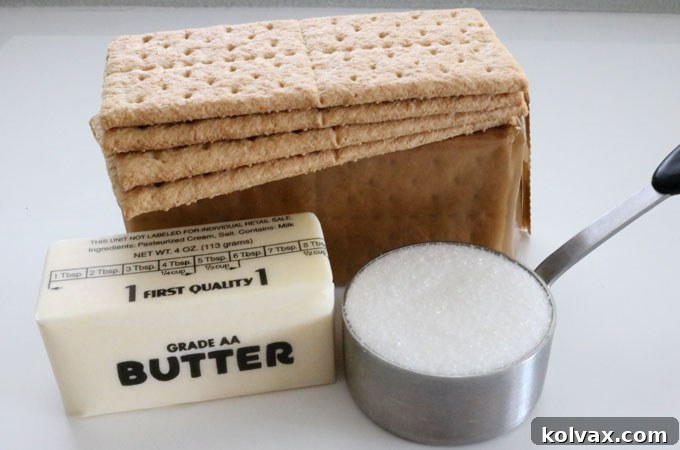 A simple array of three essential ingredients: graham cracker sheets, melted butter, and granulated sugar, ready to be transformed into a delicious pie crust.