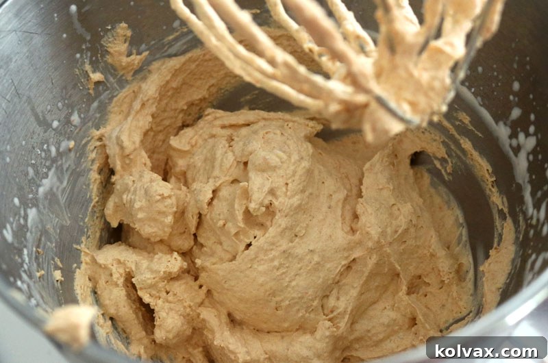 A chilled, large stainless steel mixing bowl, prepared and ready to whip cold heavy cream for the perfect pumpkin spice frosting.