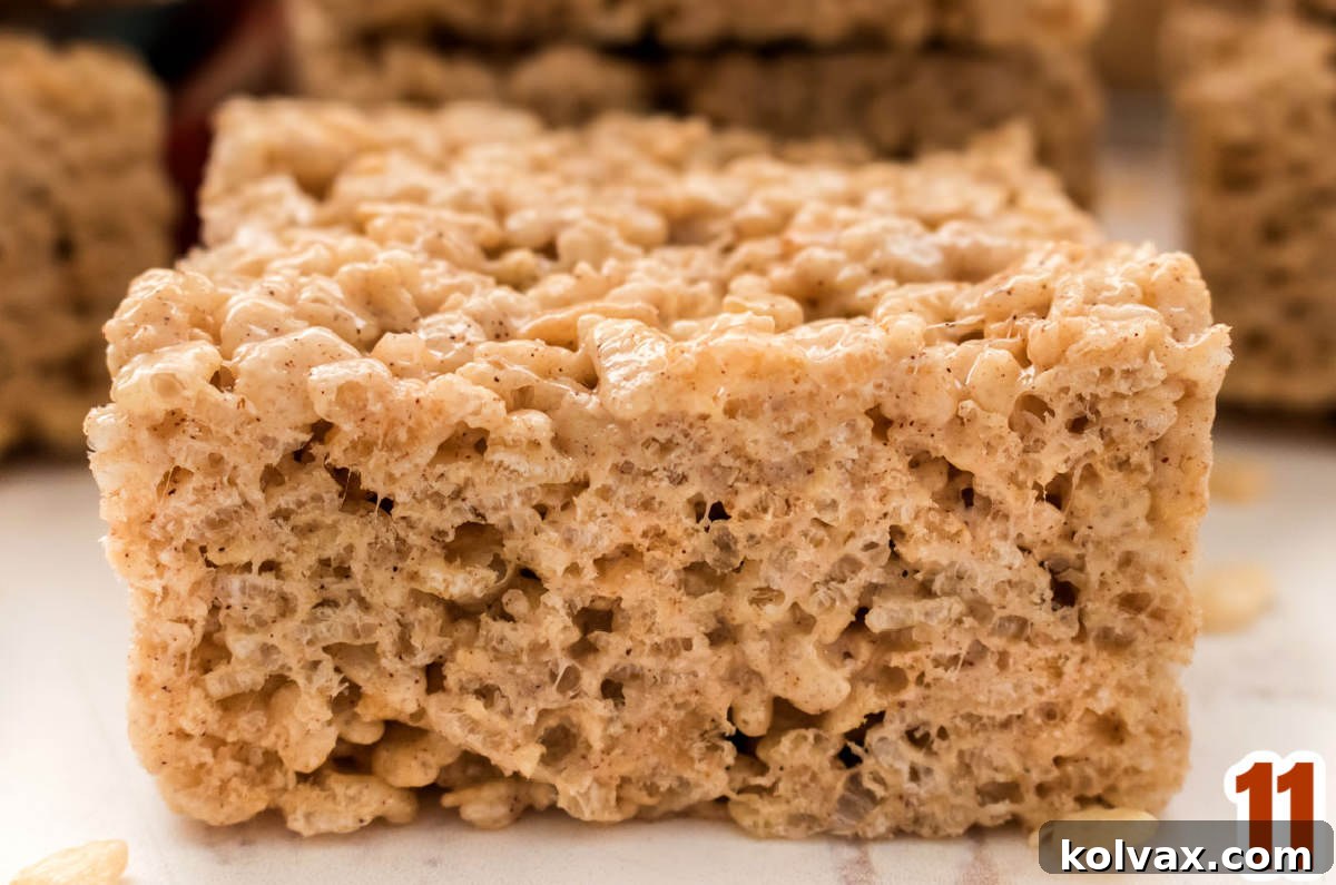 Closeup on a single serving of a Pumpkin Spice Rice Krispie Treat showing the specks of spices combined with the marshmallow mixture.