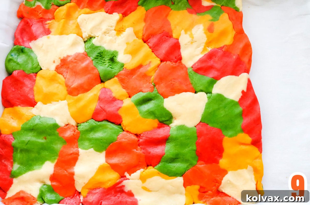 Marbled Harvest Sugar Cookie Bars 7 Marbled sugar cookie dough, with various fall colors swirled together, pressed evenly into a parchment-lined cookie sheet, ready for baking.