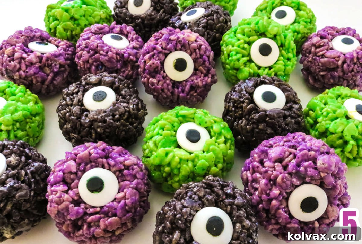 An artistic scattering of purple, black, and green Monster Eyes Rice Krispie Treats on a clean white surface, showcasing their vibrant colors and creepy candy eyes.