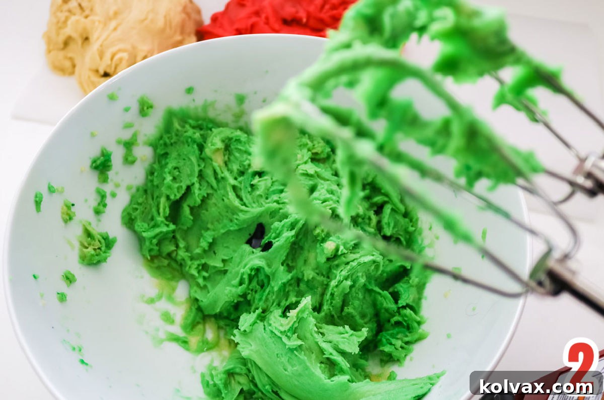 Closeup of the sugar cookie dough perfectly separated into three portions and vibrantly colored in green, red, and white, ready for marbling.